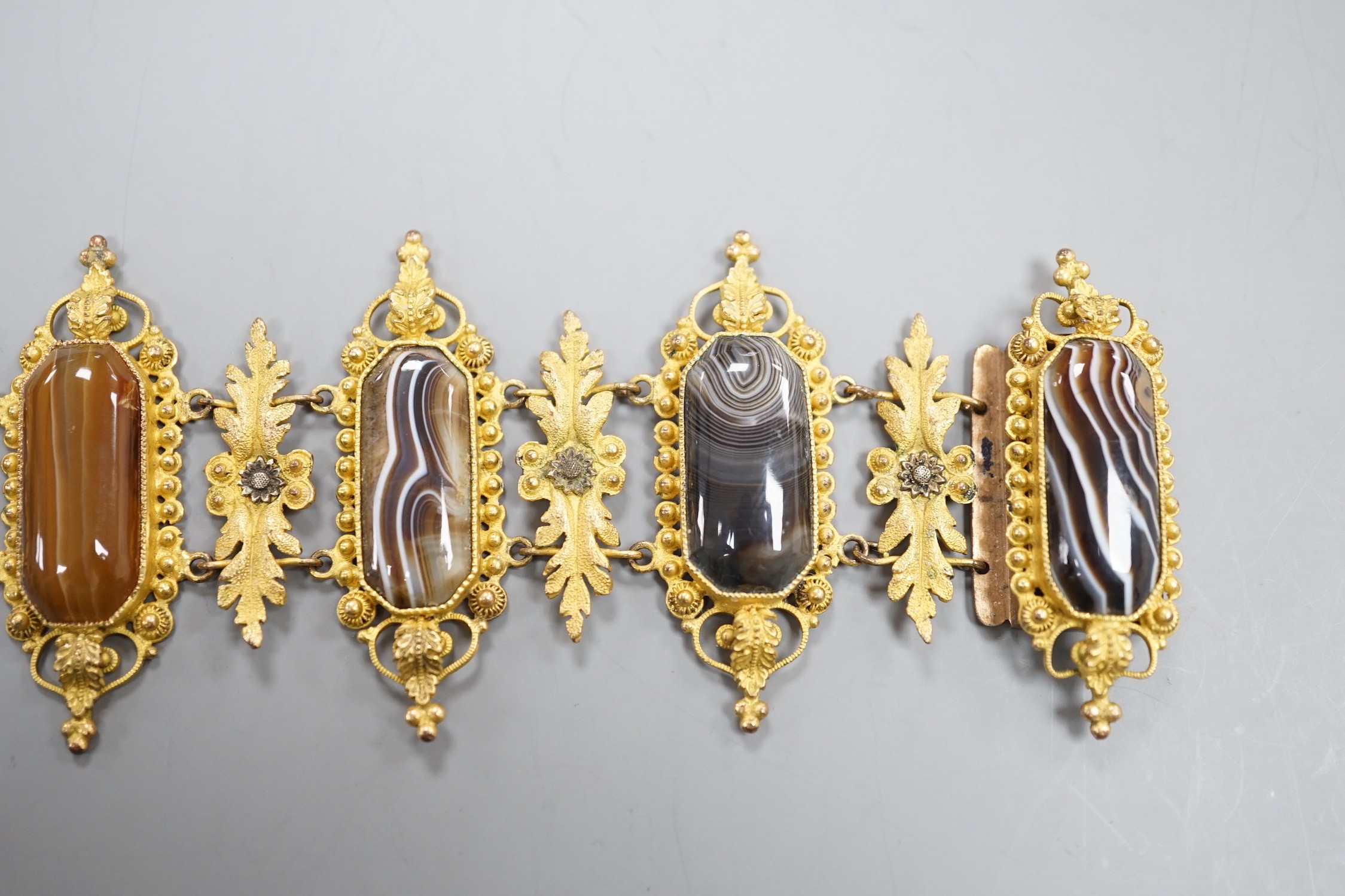 An ornate late Victorian pinchbeck and six stone banded agate set bracelet, 18.5cm.